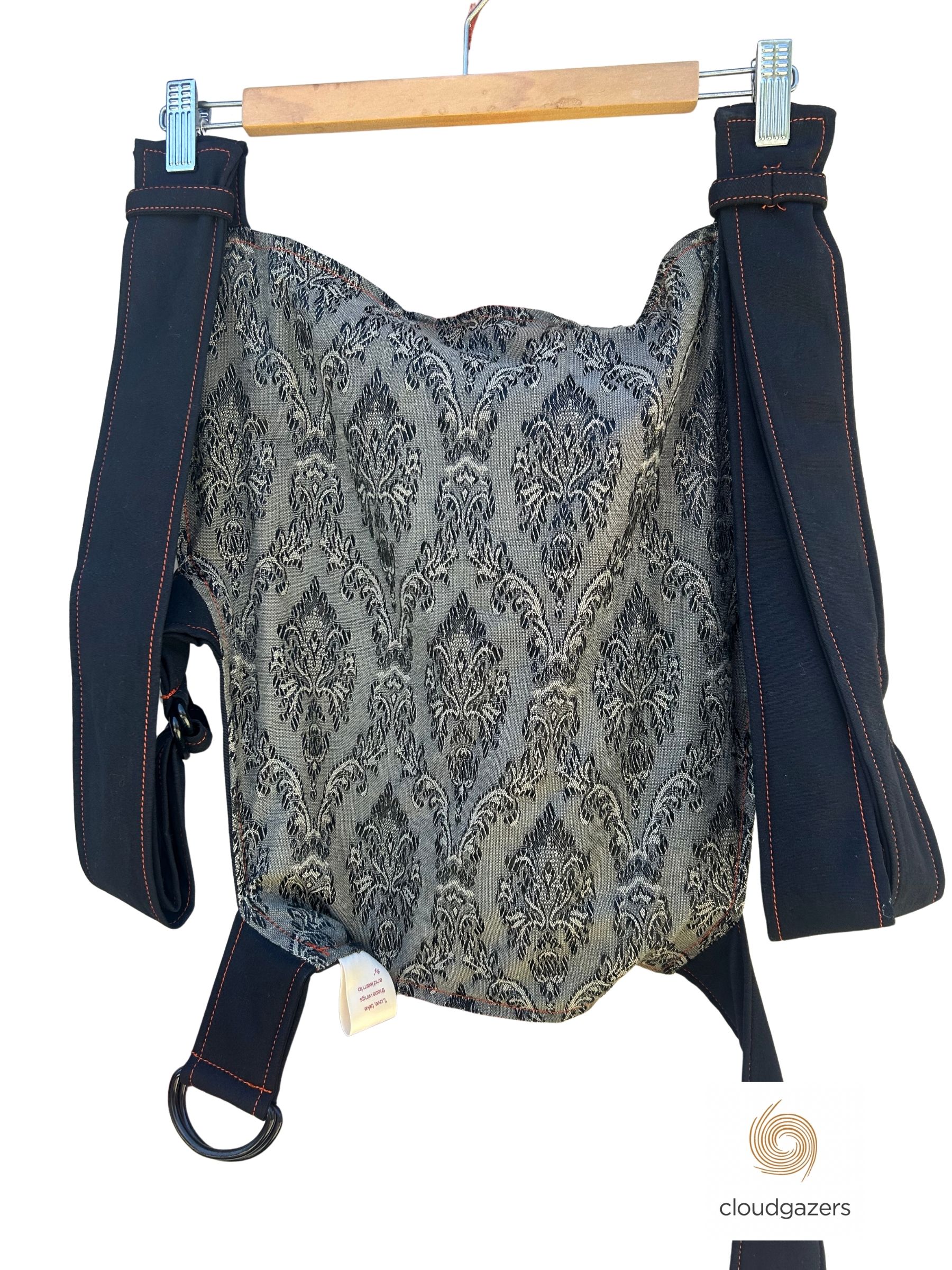 Baby Carrier Handmade One-of-One showcasing a unique black and silver damask pattern, highlighting sustainable fashion values.